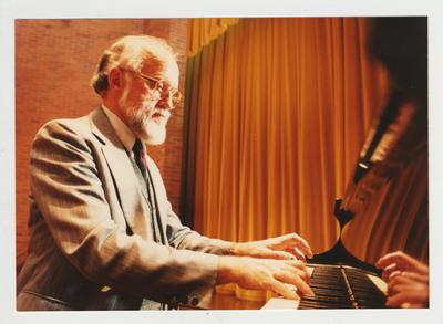 A man plays the piano in an auditorium