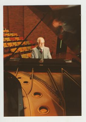 A man plays the piano in an auditorium