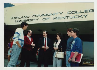 A group of people stand talking in front of Ashland Community College