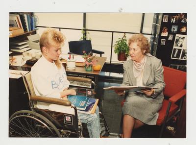 Marie Brake (right), Coordinator of Handicapped Student Services, helps an unidentified female student in her office