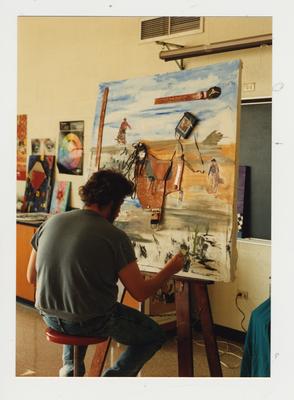 Unidentified male student paints in a classroom at Ashland Community College