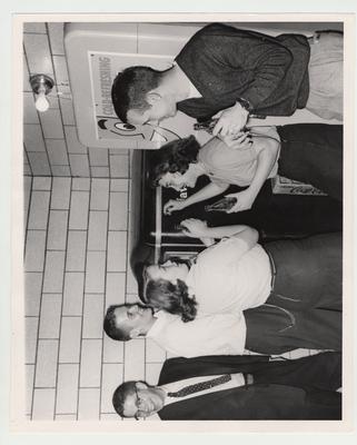 From left to right: Sidney Austin, Joseph Hill, Ruth Webb, and Barbara Rucker Cluster stand around a Coke machine