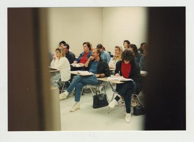 Students listen and take notes during a classroom lecture