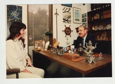 A group of three talks in an office