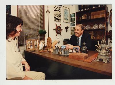 A group of three talks in an office