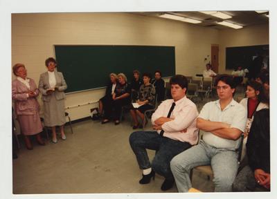 A group of people listen and watch during a workshop on grief