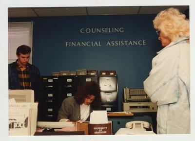 A woman helps students in the Counseling Financial Assistance office