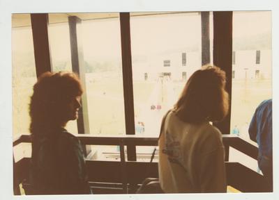 Students look out a window towards an unidentified building