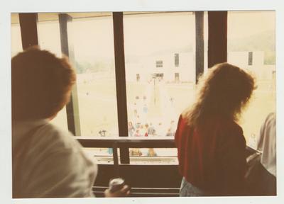 Students look out a window towards an unidentified building