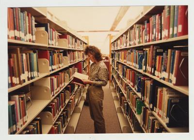 A female student looks for a book in the library