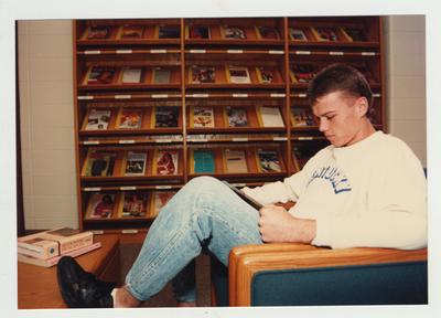 A male student reads in the library