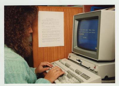 A female student works on a computer in the library