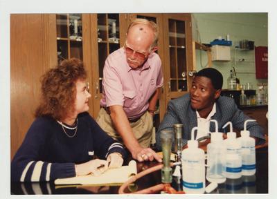 A male professor helps students in a laboratory classroom