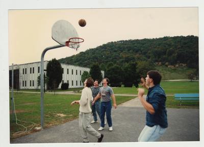 Male students play basketball