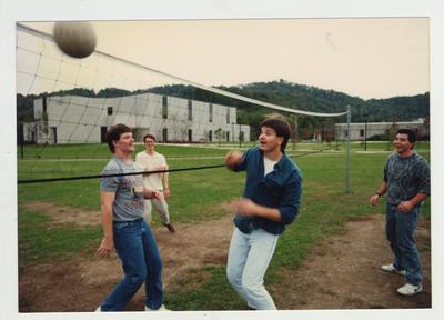 Male students play volleyball