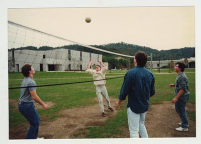 Male students play volleyball