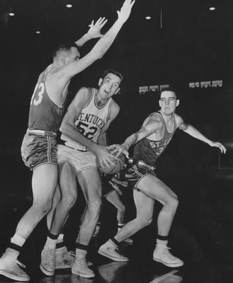 Basketball game action; Don Mills (52) is sandwiched between two St. Louis players (Bob Ferry, Glen Mankowski), 1958-59 season; AP photo; received June 13, 1959 from Cincinnati Enquirer