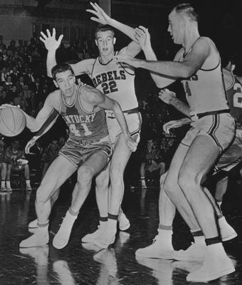 Basketball game action, UK versus Ole Miss (University of Mississippi); Bill Lickert drives past Ivan Richmann (22) and Louis Griffin (34) for a goal; received June 13, 1959 from Cincinnati Enquirer