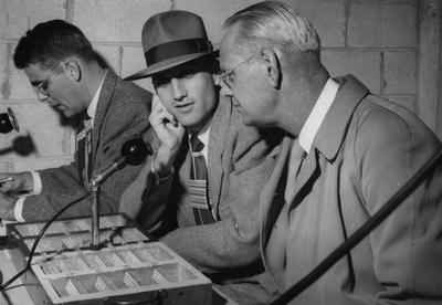 Ben Williams, J. B. Faulconer, 1939 journalism graduate and creator of first UK sports information and broadcast network, and Bernie Shively (left to right), UK Athletics Director, pictured in press box during game; photo received May 5, 1965 from the Lexington Herald-Leader