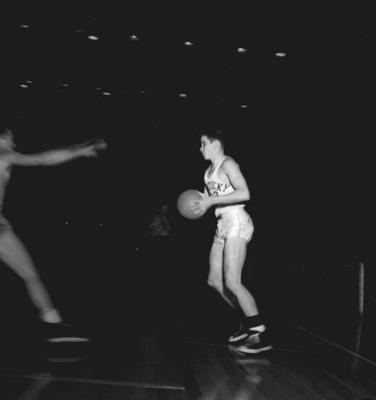 Basketball team member Bill Spivey taking a shot during game against unidentified opponent