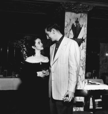 Alex Groza talking with an unidentified woman at party honoring coach Adolph Rupp and the basketball team