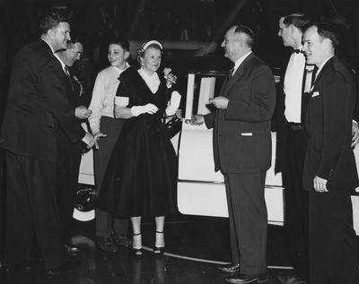 Basketball coach Adolph Rupp and spouse with new Cadillac given by the university in honor of Rupp's and UK's NCAA championships; photographer:  John Mitchell