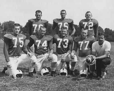 Several members of 1957 UK football team; kneeling left to right are Harry Johnson, Al Appleby, Bill Harmon, Bill Bloomingdale, and coach John North; standing left to right are Don Sinor, Bill Scott, and Bob Hunt