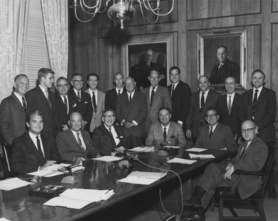 UK Athletics Association meeting in the Administration Building board room.  Standing from the left:  Mathews, Tim Futrell (Student Government President), Joe L. Massic, Lyman Ginger, Tom Brower, Don Lee (Manager), Rusty Wright, James Pence, J. T. Frankenberger, Nick Pisaceud, Steve Diachum, and Wimberly Royster.  Seated from the left:  Glenwood Creech, D. Angelucci,  Ab Kirwan, Coach Lancaster, and President Otis Singletary