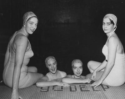 Four unidentified women in caps and swimsuits, posing by the pool; members of the Blue Marlins aquatic ballet club
