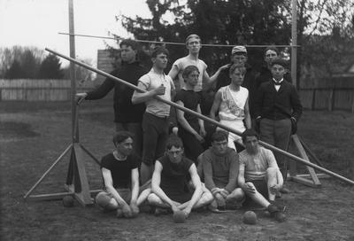 Twelve unidentified members of the State University Track team, pole vaulting and shot put; print from Nollau glass negatives