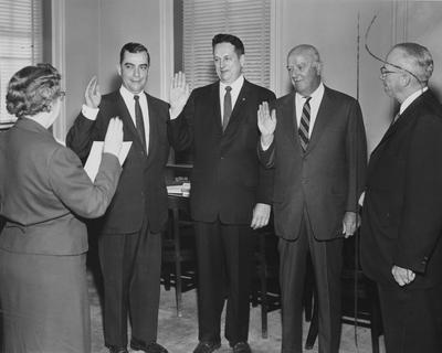 Esther McChesney swearing in new University of Kentucky Board of Trustees members; names of individuals listed on photograph sleeve; Lexington Herald-Leader photo