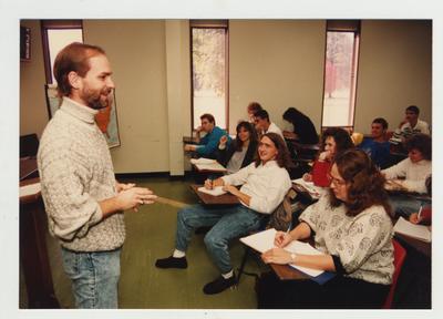 Students listen as a male professor listens in a classroom