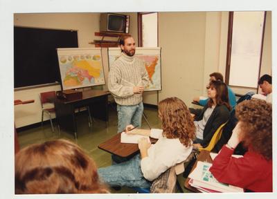 Students listen as a male professor listens in a classroom