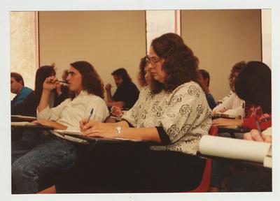 Students listen and take notes during a lecture in a classroom