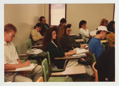 Students take notes during a lecture in a classroom