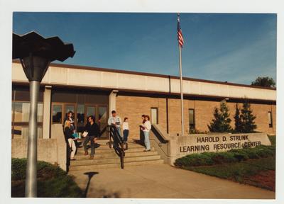 Students stand in front of the Harold D. Strunk Learning Resource Center