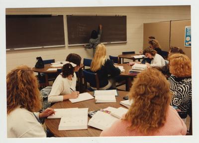 Students take notes during as an unidentified female professor lectures in a Foreign Language class