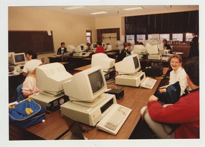 Students type on computers in a classroom