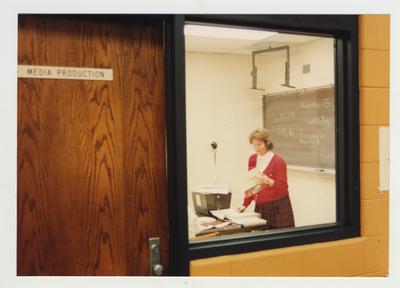 A female professor teaches in the media production room of the library