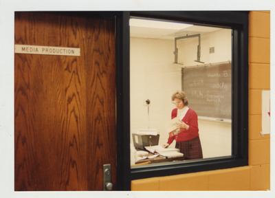 A female professor teaches in the media production room of the library