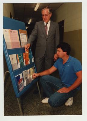 A man shows brochures to an unidentified male student