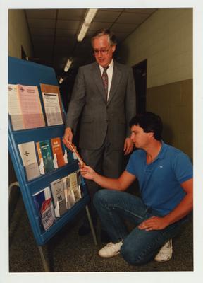 A man shows brochures to an unidentified male student