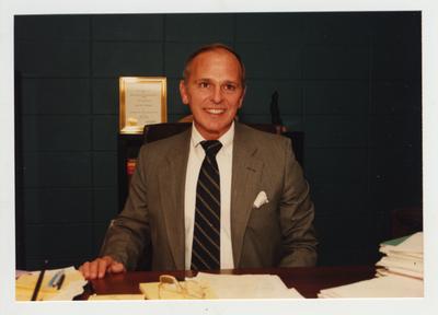 An unidentified man sits at his office desk