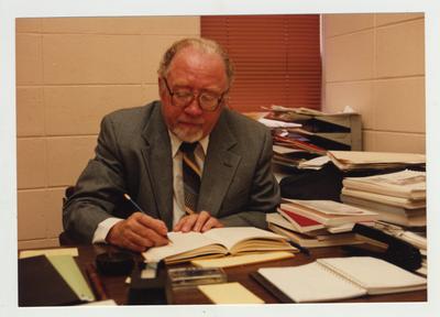 A man sits working at his desk