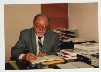 A man sits working at his desk