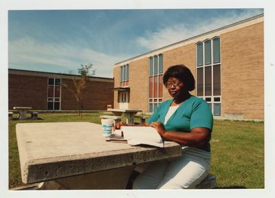 A female African - American student studies outside