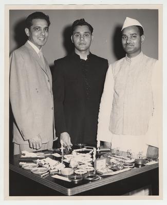 University of Kentucky students celebrate the 10th anniversary of the Republic of India's independence; Shown looking at an exhibit of handmade Indian objects are from left to right: Kann Shah, a former University of Kentucky student working in Lexington, and UK students Satish Chand Markanda and Govind Khandanpur