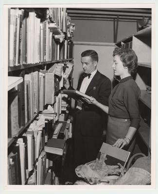 Surplus books, distributed by the United States Library of Congress, are unpacked for use in the University of Kentucky libraries by Jim Gribble and Loraine Noel