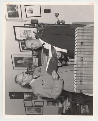 Commandant Robert E. Tucker presents books from the Army to Director of Libraries Lawrence S. Thompson