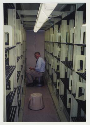 Bill Marshall cleaning shelves in the core stacks in the Margaret I. King Library